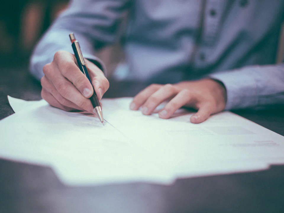 Executive signing an agreement at a desk