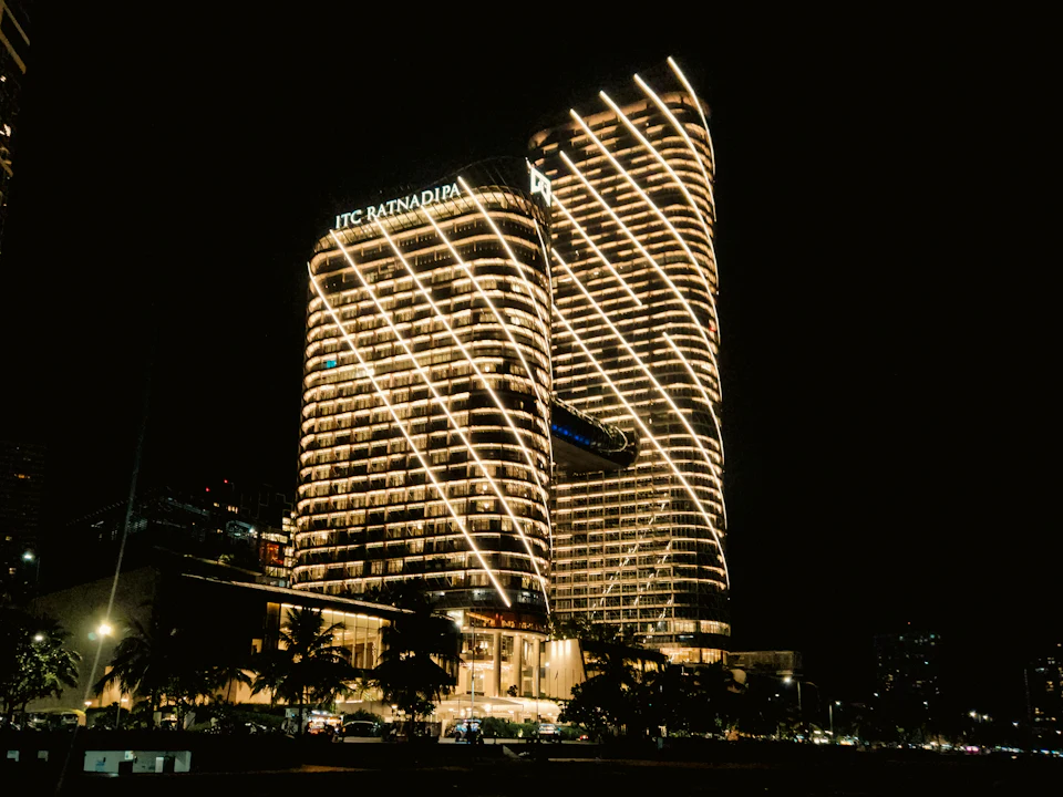 Modern tower lit in gold against the night sky